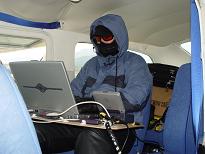 Curtis Belyea bundles up to monitor the equipment inside the plane.